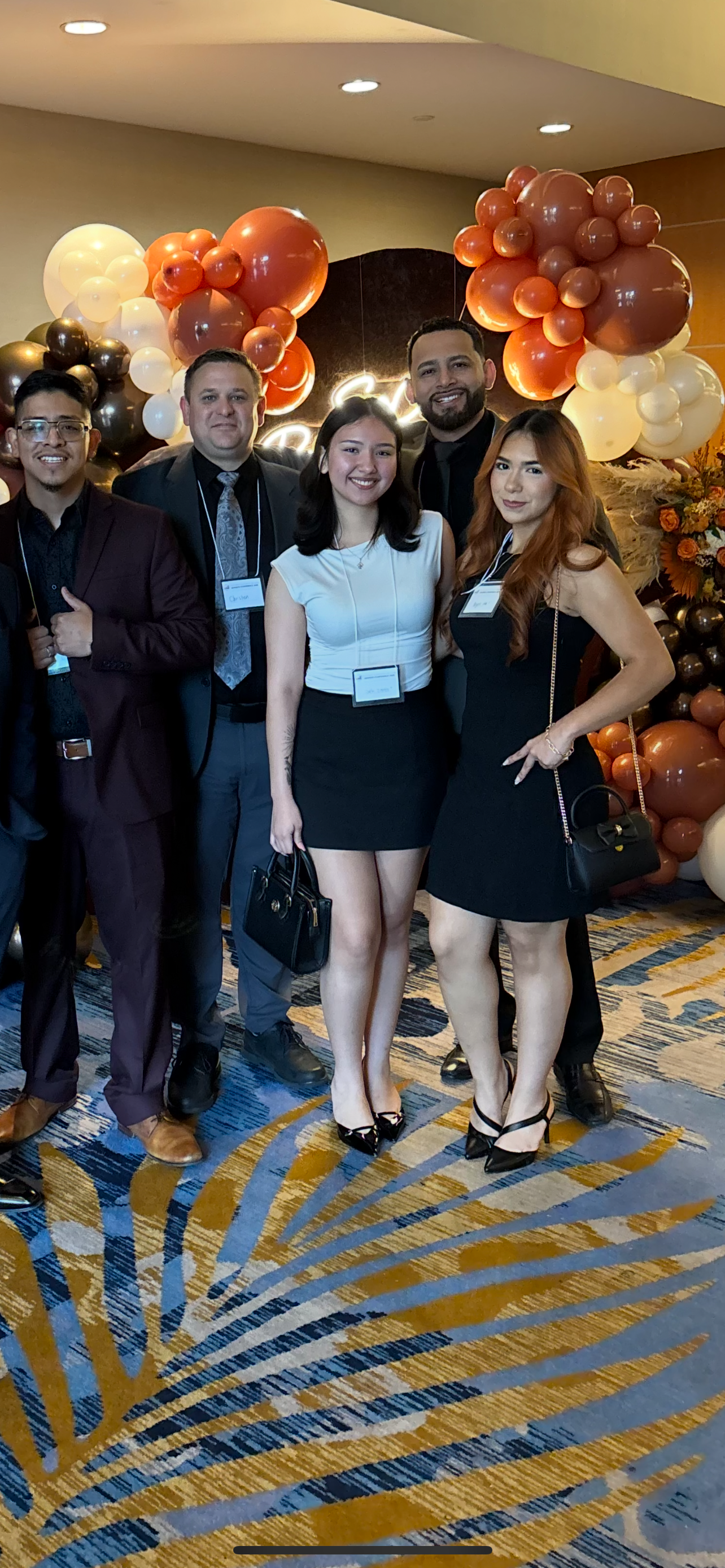 Infinite Reign Solution group of five team members at a company event with orange balloons